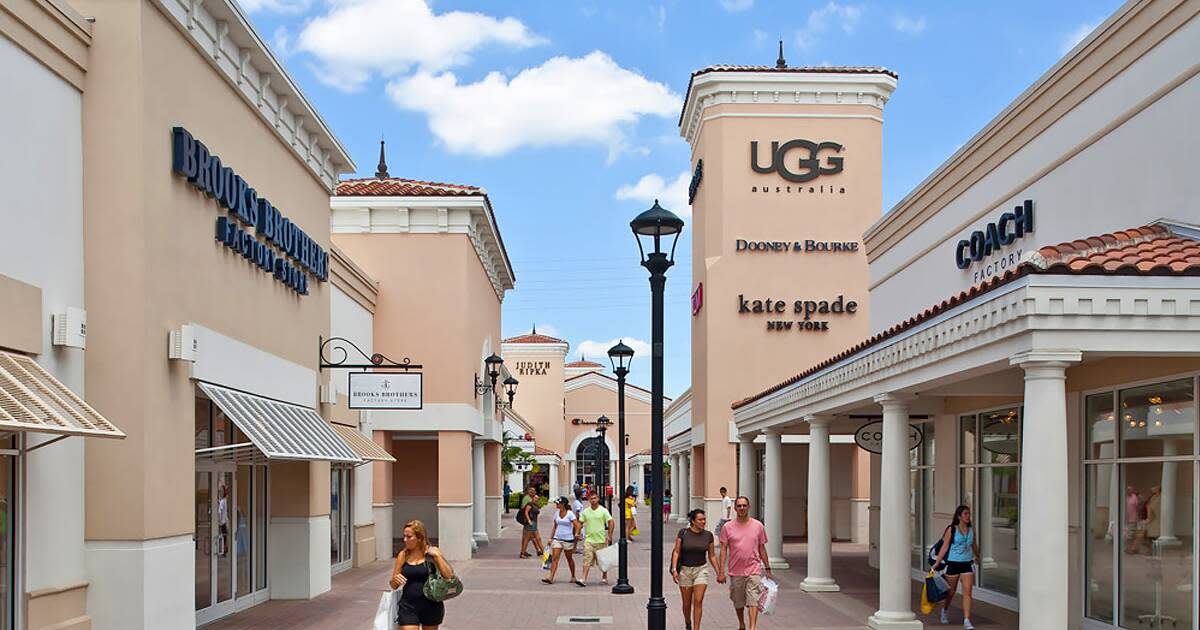 Storefronts at Millenia Mall and Premium Outlets, lined with palm trees